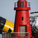 Costa Concordia looms behind a lighthouse.
